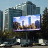 Large digital billboard displaying a cityscape with tall buildings and trees.