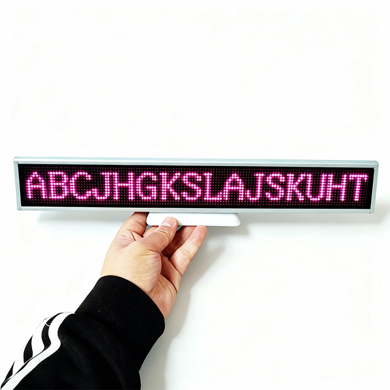 Hand holding Leadleds Mini Battery Operated LED Sign with pink scrolling text – portable rechargeable programmable message board