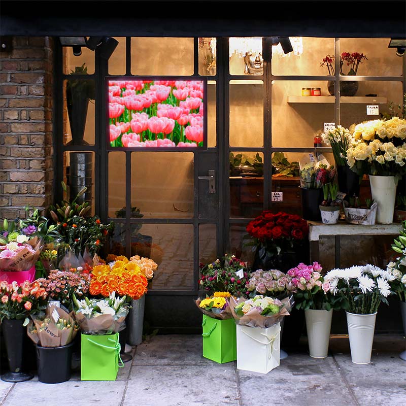 Floral shop with a variety of flowers displayed outside a store entrance.