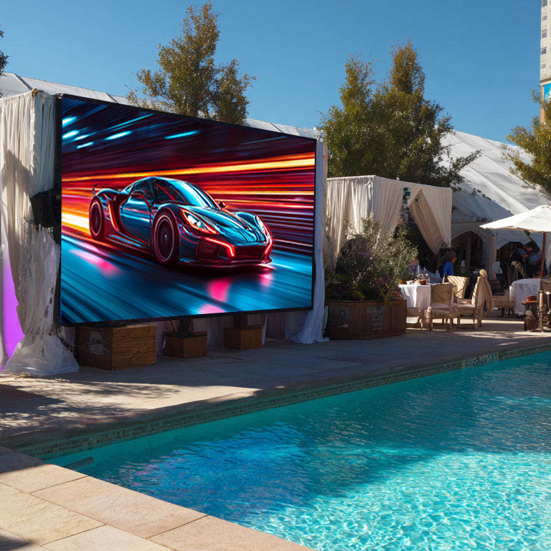 Outdoor setting with a large screen displaying a car graphic near a pool.