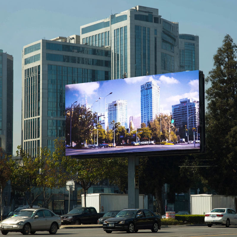 Large digital billboard displaying a cityscape with tall buildings and trees.