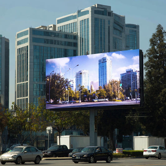 Large digital billboard displaying a cityscape with tall buildings and trees.