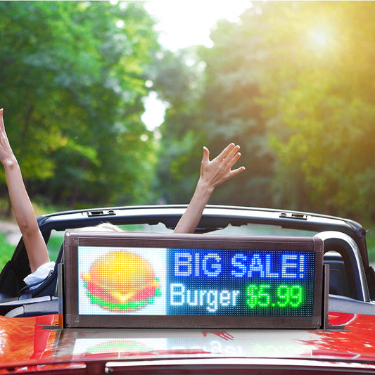 Digital sign on a car roof advertising a big sale with a burger offer, outdoors.