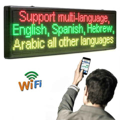 Person using a smartphone to control an LED sign displaying multiple languages.