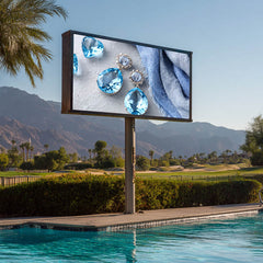 Outdoor digital display screen showing jewelry near a pool with mountains in the background