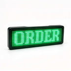 White LED digital scrolling name tag attached with magnetic pin to work uniform displaying HELLO text message