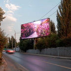 A large outdoor LED billboard mounted on a roadside pole