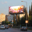 LED Billboard displaying a scenic image of flowers on a city street with cars and buildings